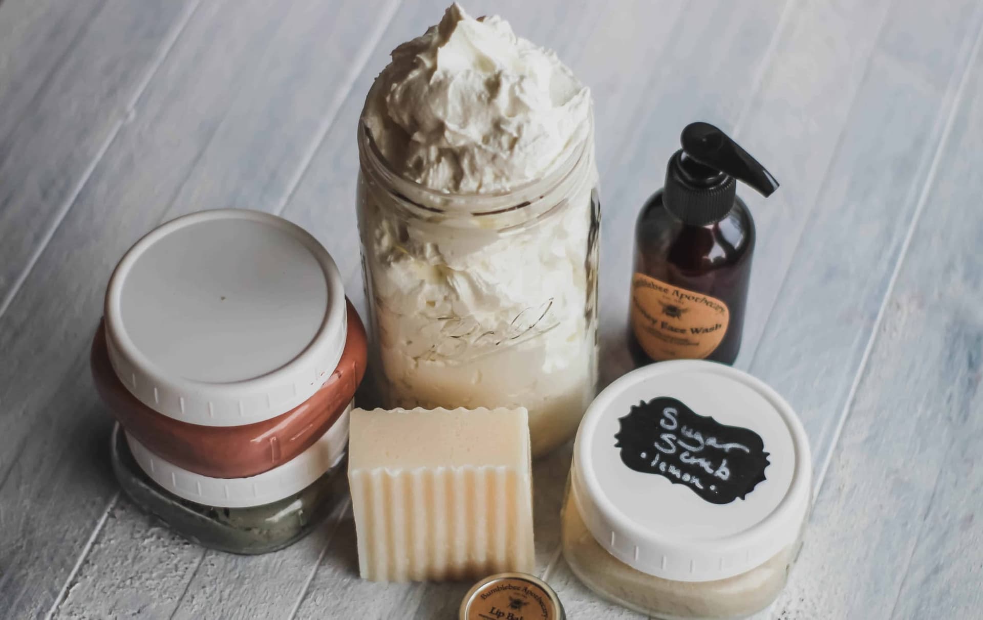 A collection of Bumblee Apothecary skincare products, soaps, pastes and powders in canned packaging.